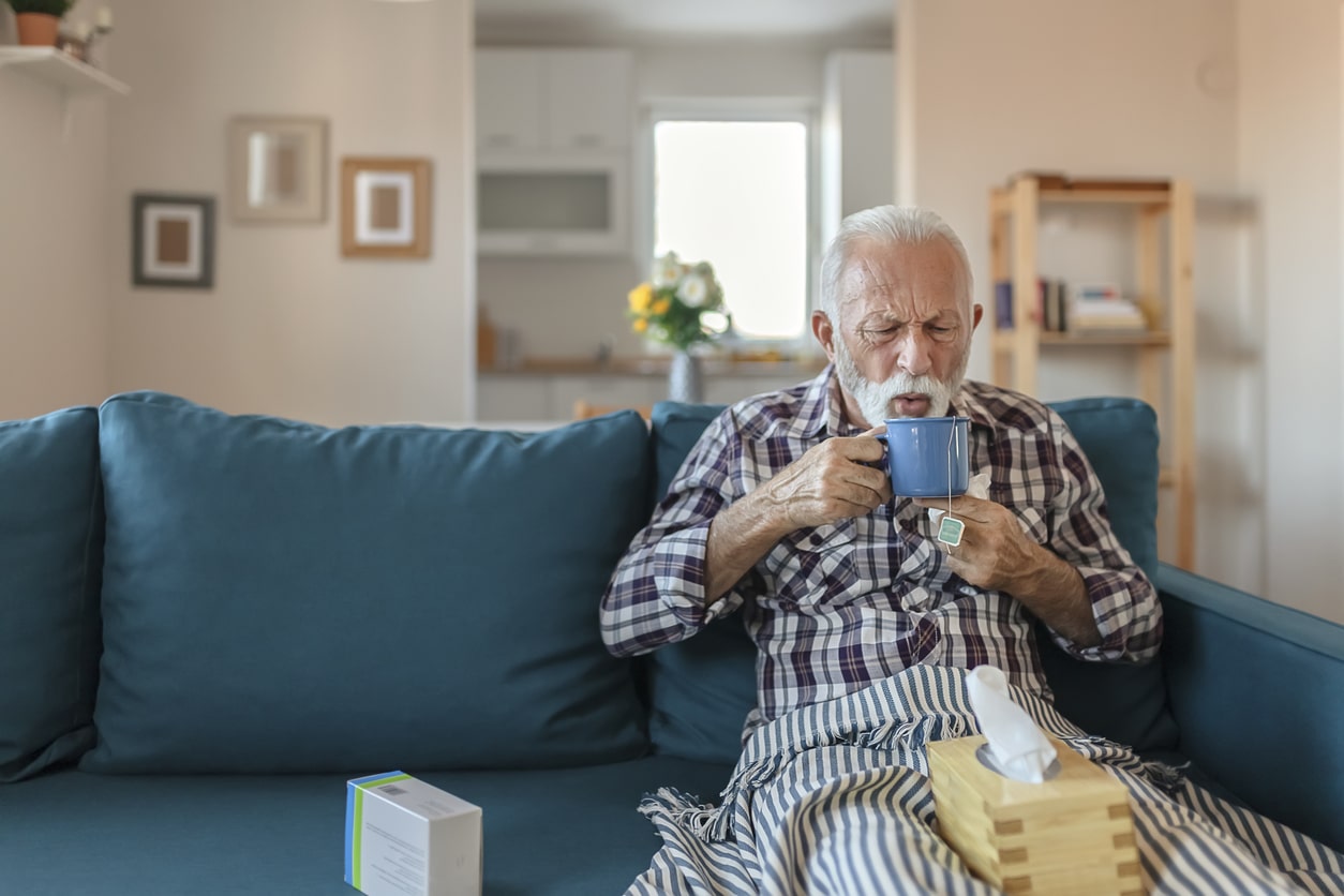 older man drinking tea after learning about common flu myths for seniors