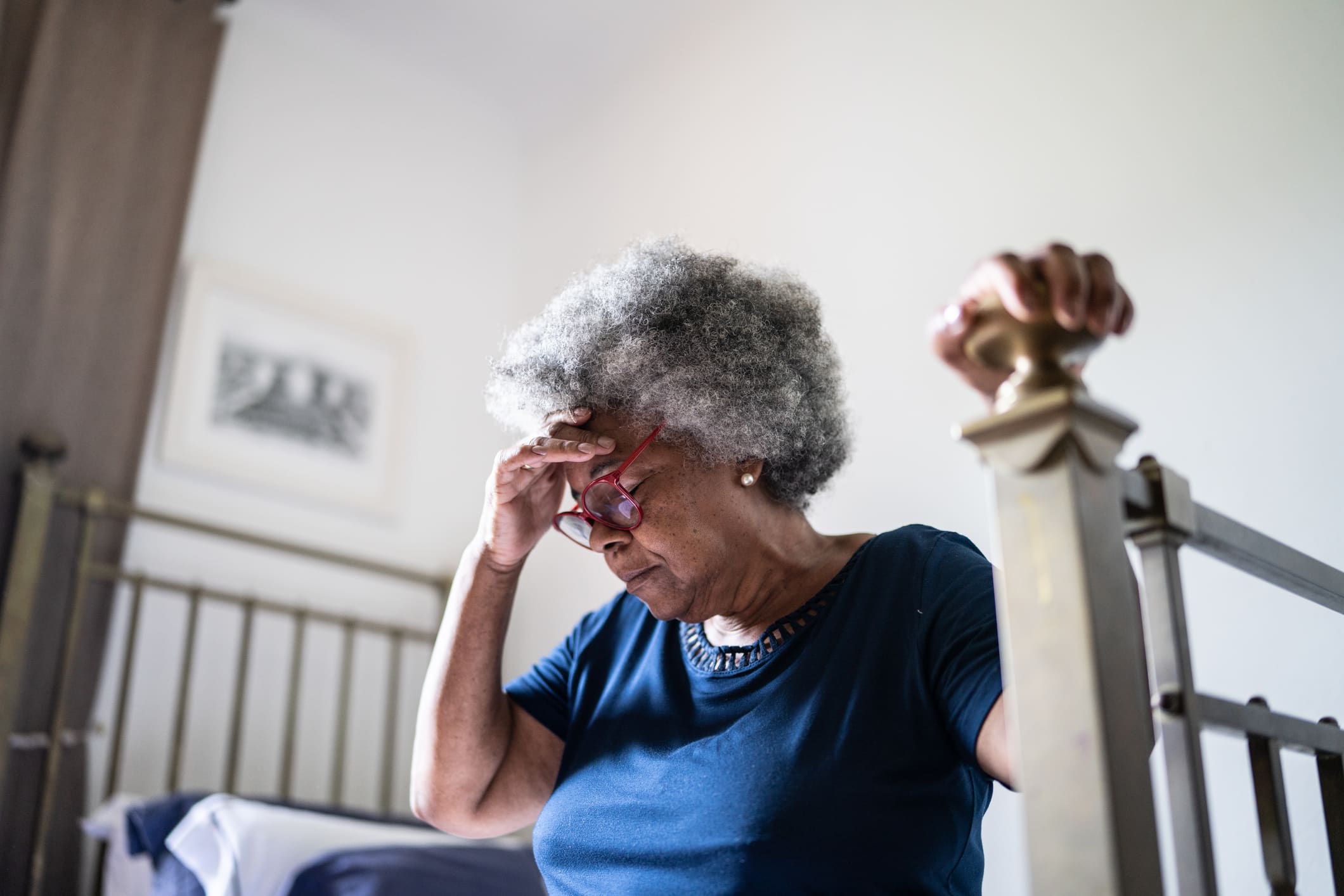 older woman feeling dizzy as she feels signs of a stroke