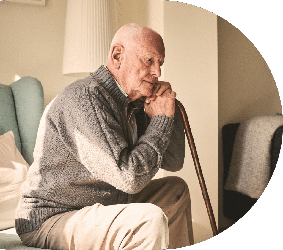 senior man sitting and thinking with a cane while struggling with memory issues from dementia in seniors