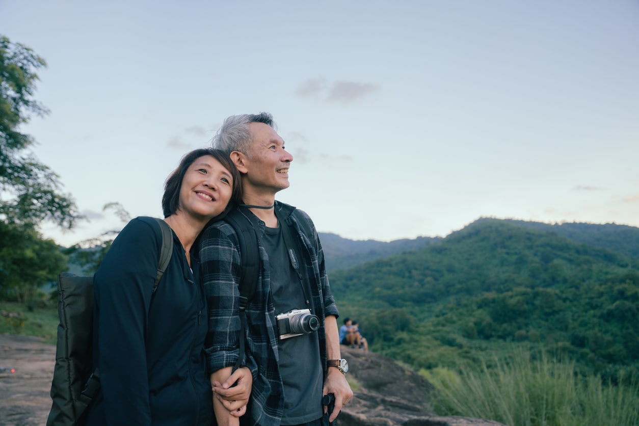 Older couple smiling and hiking while finding purpose in retirement