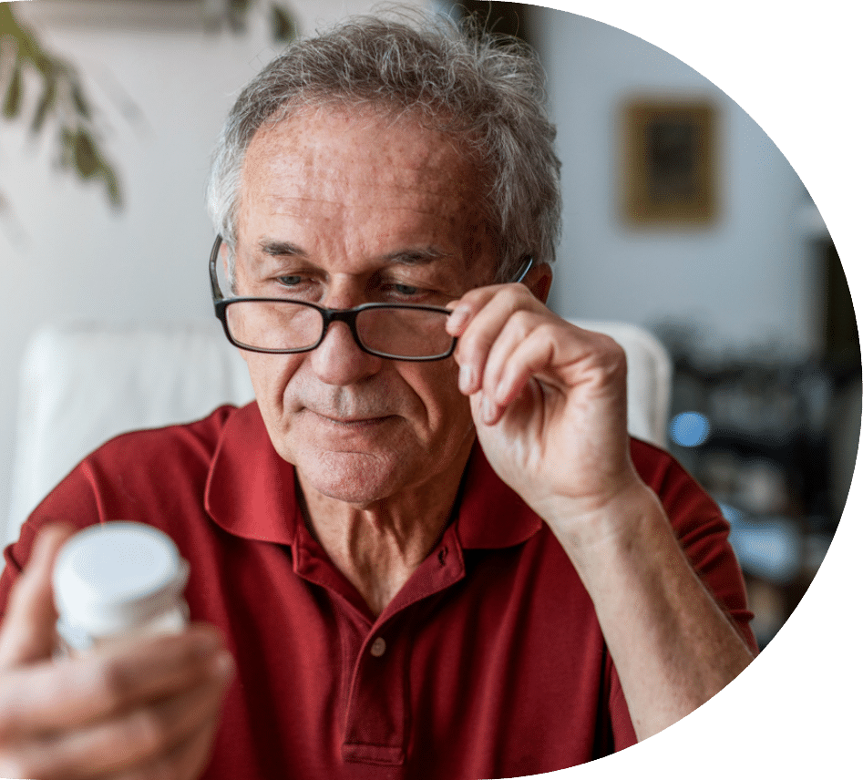 Elder man looksat a prescription bottle for famotidine