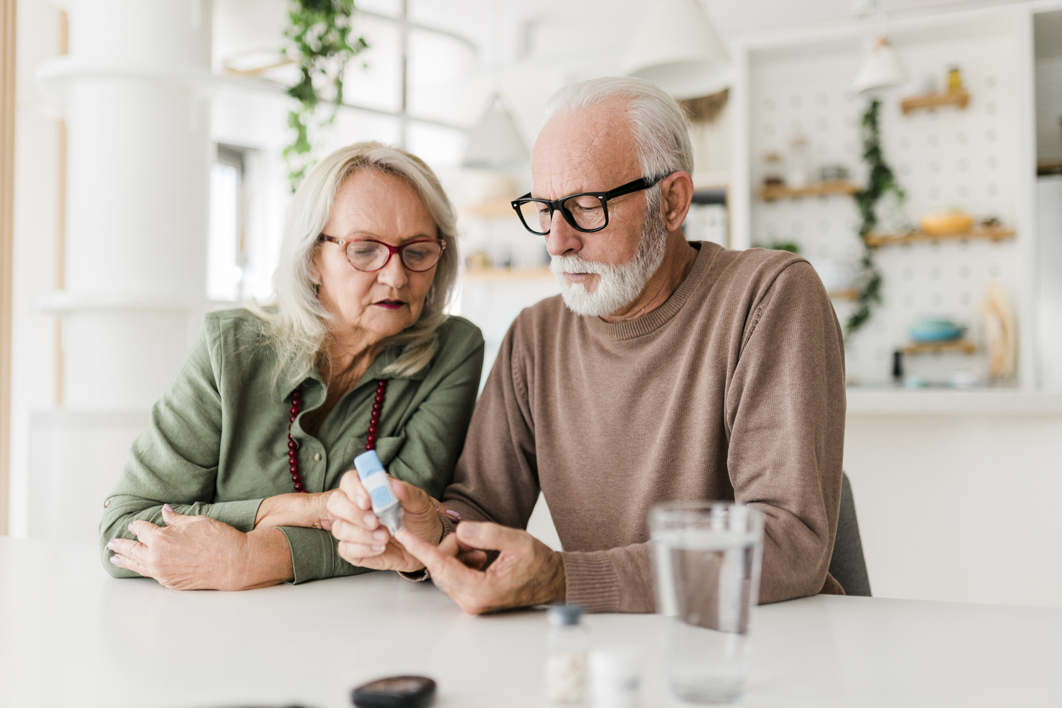 Senior couple using lancet on finger for checking blood sugar level by Glucose meter, Healthcare and Medical, diabetes, glycemia concept