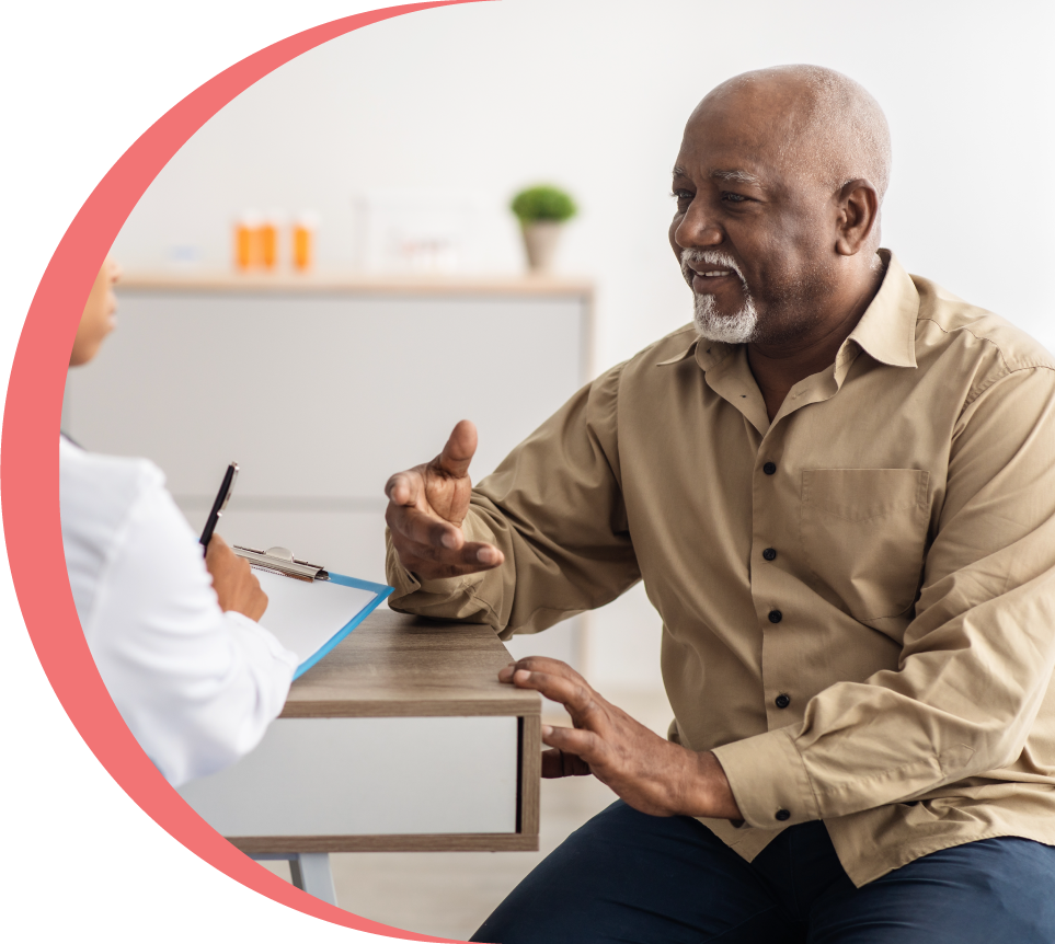 Man sitting at a desk talking with a primary care clinician